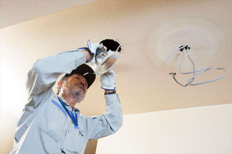 天井の電気線を整備している男性作業員